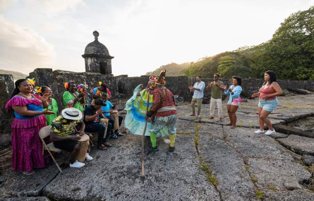 Group of Congos dancing wearing colorful polleras outside Fuerte San Fernando at Portobelo, Colon province
