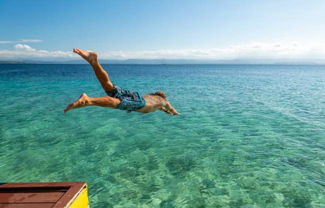 Hombre lanzándose al mar en aguas cristalinas del Caribe de Panamá
