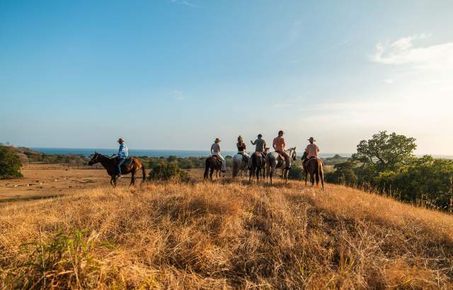 Group of tourist horse riding at Cambutal on a clear day, Los Santos province