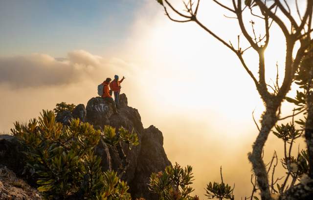 Casal no topo do Vulcão Barú ao pôr do sol, com vista panorâmica sobre um mar de nuvens. Em dias claros, deste ponto é possível ver o Oceano Pacífico e o Atlântico.