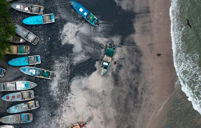 View of black sand of Gorgona beach, fishing boats