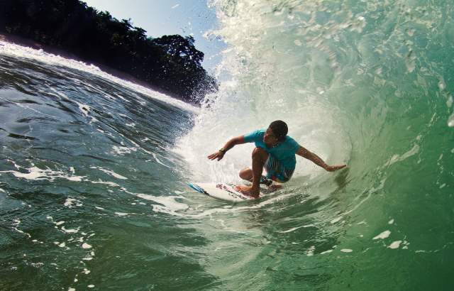 Surfer A surfer rides the perfect barrel in the pristine waters of Bluff Beach.