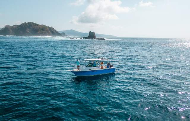 Sportfishing boat in Panamá’s coastal waters, with a mountainous landscape in the background and open sea ideal for world-class fishing