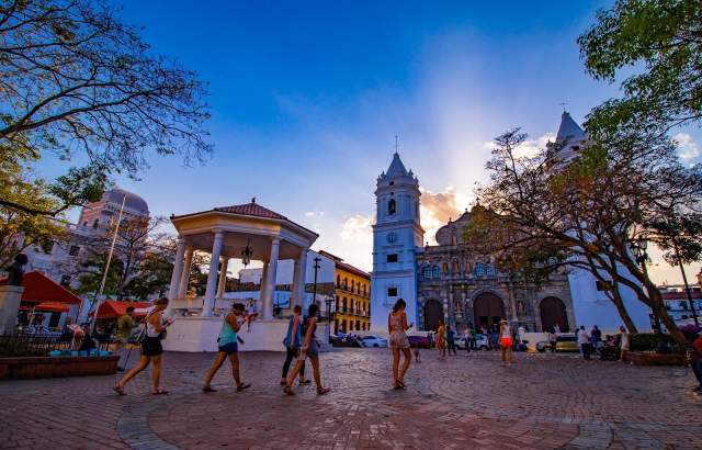 Sunset behind the Metropolitan Basilica Cathedral Santa Maria La Antigua and Plaza Catedral (Independence Square) filled with visitors (side view)