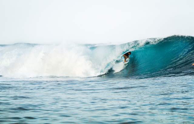 Surfista em uma onda enorme, azul e perfeita na província de Bocas del Toro, Panamá