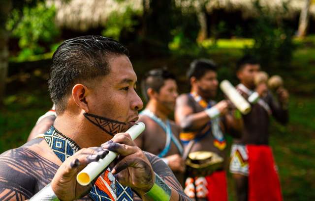 Embera playing typical music, dressed with colorful clothes