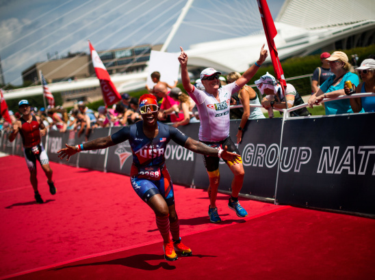 triathlete crossing the finish line in front of the Milwaukee Art Museum at the 2022 USA Triathalon