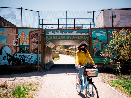 woman biking under Valley Passage Bridge