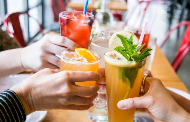Four people cheersing cocktails at Cardinal Spirits