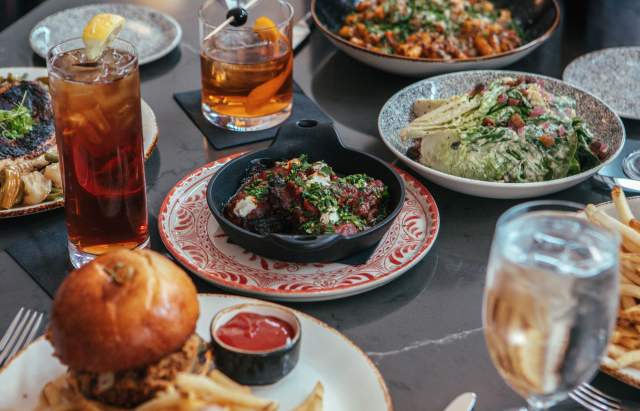 A table full of tasty dinner options from Amor&eacute; in downtown Fort Wayne. Setting includes drinks, salads, sandwhich, and pasta dishes.