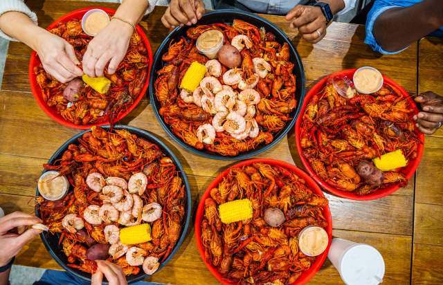 various platters of crawfish served with boiled shrimp, corn, and potates
