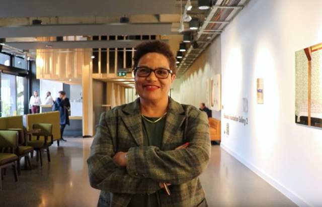 Poet Jackie Kay stood smiling in a conference area
