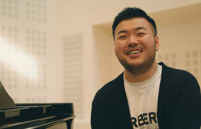 Leo Yu smiling in front of a piano