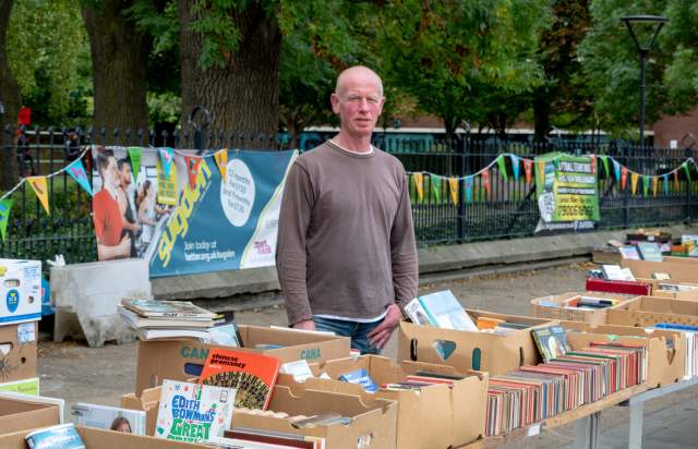 A book seller based in Manchester stood by his stall.