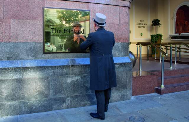 Doorman at Manchester's Midland hotel straightening his tie.