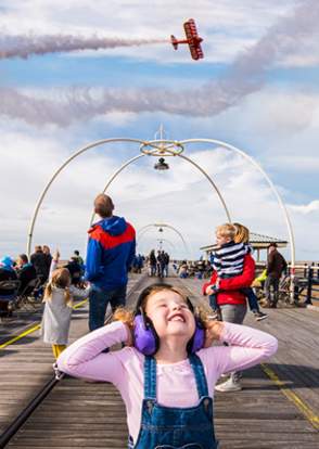 Child on pier covering ears