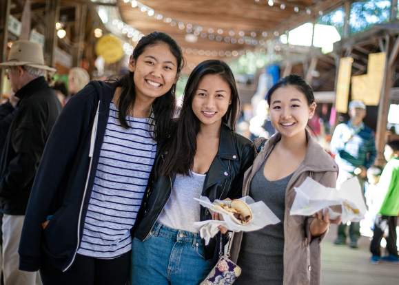 three students eating at Ithaca Farmers Market