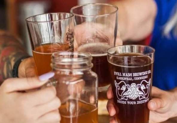 four people holding glasses of beer in a cheer