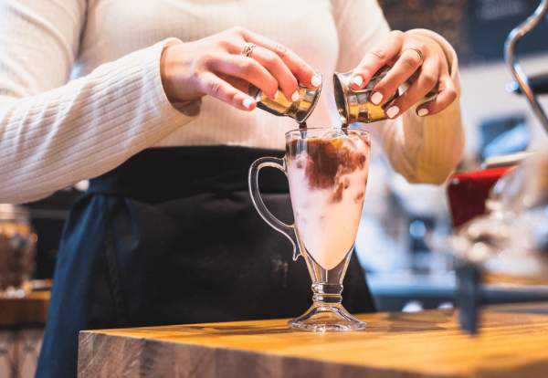 woman pouring chocolate into a glass of milk