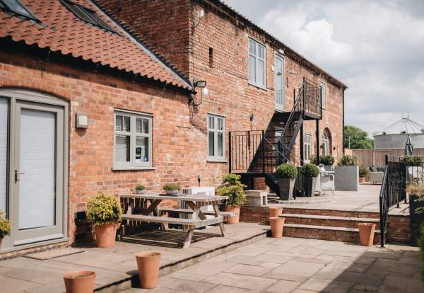 Accommodation exterior with picnic benches and plants