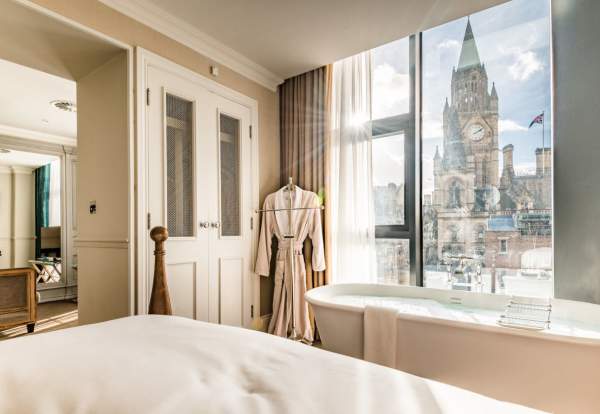 Hotel bedroom with bathtub and view to Manchester Town Hall