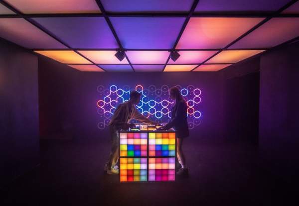 Two people a colourful interactive cube a part of SUPERMASSIVE interactive experience