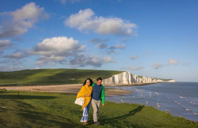 A man and woman walk along the cliffs at Seven Sisters, Sussex