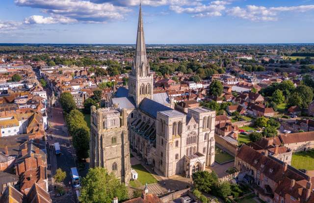 An aerial view of Chichester Cathedral and spire with surrounding streets of Chichester