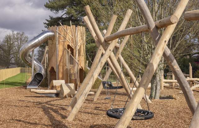 outdoor play area at Leonardslee Lake & Garden showing wooden climbing structures and a spiral slide
