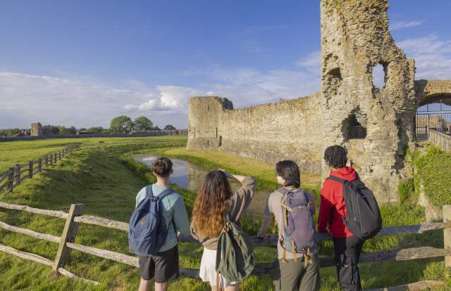 Group look at the ruins of Pevensey Castle in 1066 country, Sussex
