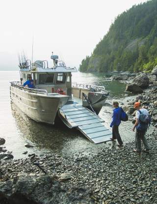 Two people board a water taxi at kayakers cove