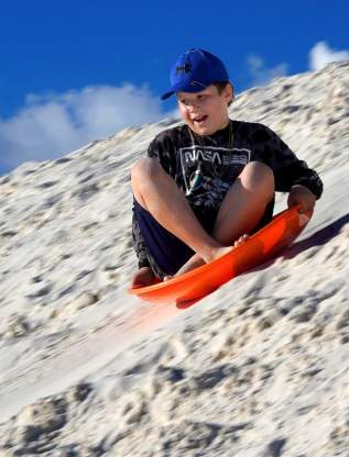 White Sands Boy Blue Hat Sledding