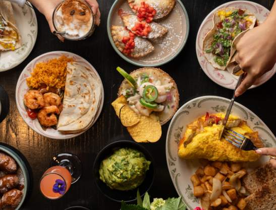 Overhead shot of brunch dishes like omelets, tacos and cocktails at Kavas Tacos + Tequila Orlando