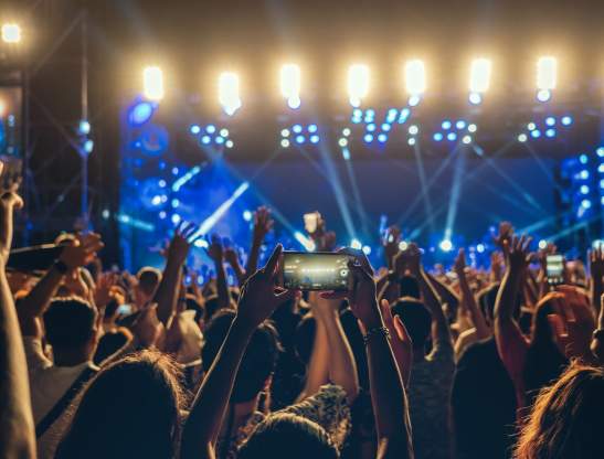 Concert crowd of Music fanclub hand using cellphone taking video record or Live stream with superstar songer, happy new year, christmas and festival concept