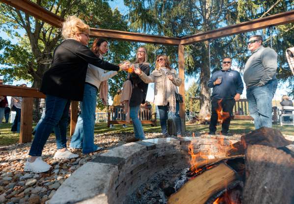 Attendees gather around a warm bonfire at Bonfires, Barrels & Brews. The Laurel Highlands Pour Tour signature fall festival.