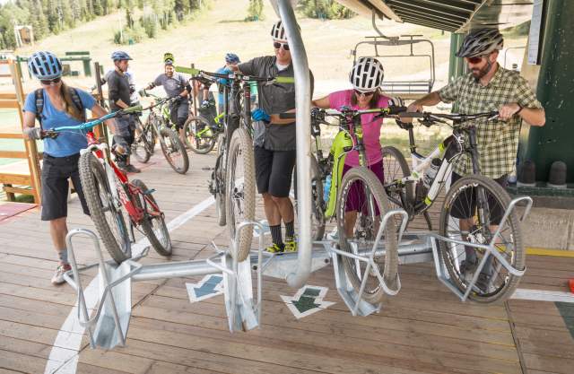 Group loading mountain bikes onto chairlift at Deer Valley Resort.