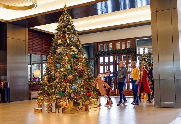A family admiring the Christmas tree at Omni