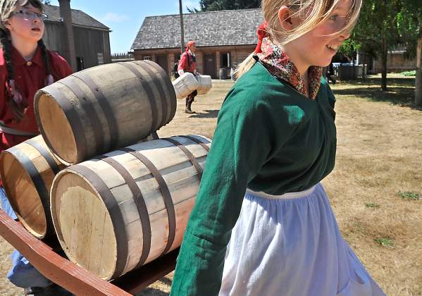 Two young girls at Fort Nisqually dress in period clothing for living history