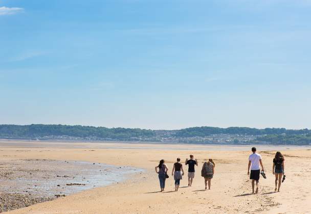 Students walking along Swansea Bay Beach