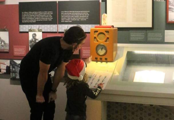 A child and father looking at an exhibit in the Dylan Thomas Centre.