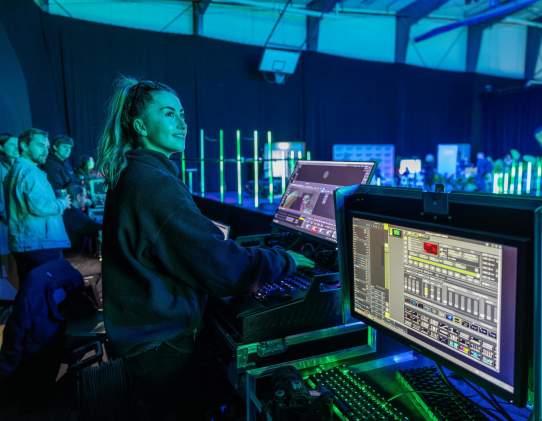 Behind the scene of event tech setup with screens and light controls