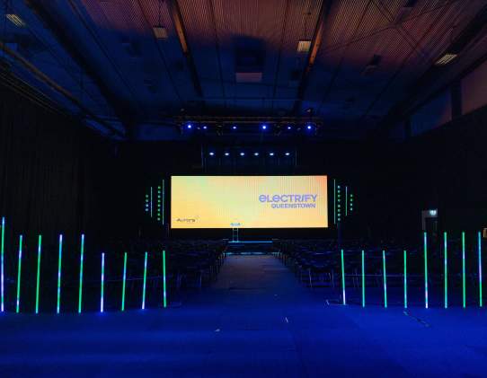 Stage, screen and light setup of an event in a dark exhibition centre