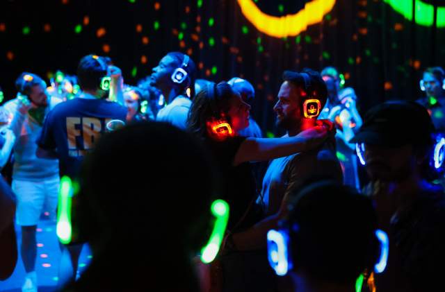 Photo of couple dancing in a crowd of silent disco goers.