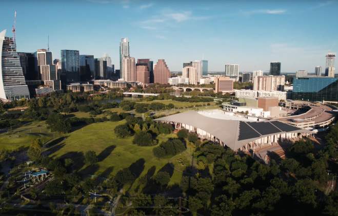 Aerial view of the Palmer Event Center and greenspace with the downtown Austin skyline in the background
