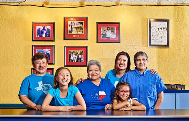 Regina Estrada and female family members smile for a portrait inside Joes Bakery and Coffee Shop