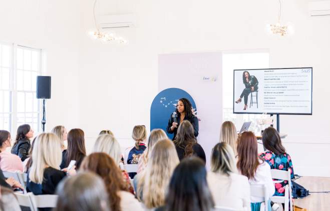 Woman speaking in front of a crowd for a conference session.