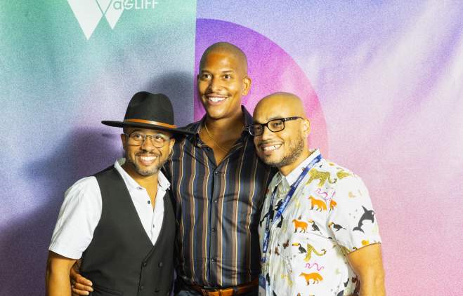 Quincy Le Near, Nathan Hale Williams and Deondray Gossett take a photo together in front of an ombre background at aGLIFF festival