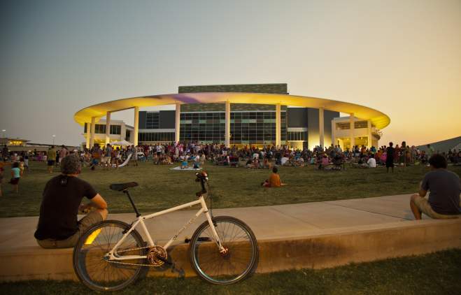 A sunset view of the The Long Center for the Performing Arts hosting a live music event in Austin, TX.