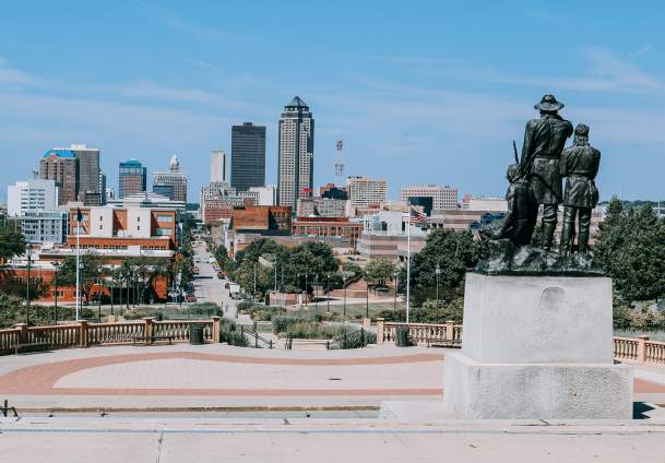 View of the statue outside the Iowa State Capitol and the Des Moines Skyline