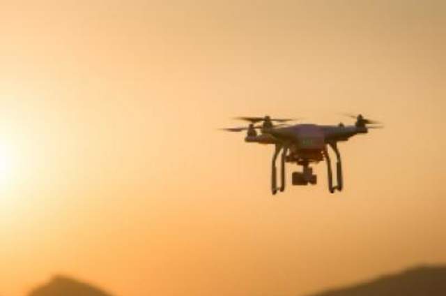 Photo of drone in flight at sunset